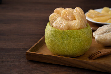 Fresh pomelo fruit on wooden table background.