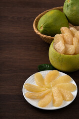 Fresh pomelo fruit on wooden table background.