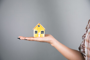woman holding wooden house model