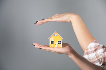 woman holding wooden house model