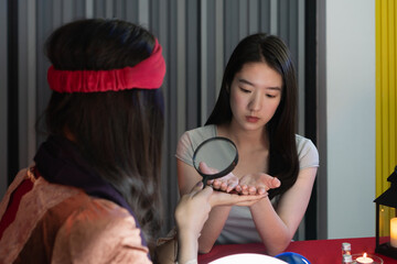 girl check palm hand destiny with a fortune teller - obrazy, fototapety, plakaty