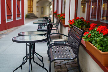 Terrace with round glass tables and metal chairs to relax and have a drink.