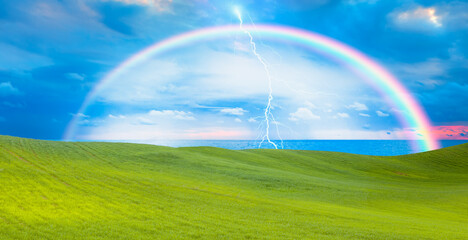 Naklejka premium Beautiful landscape with green grass field amazing rainbow in the background 