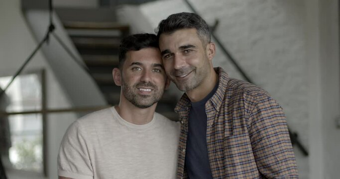 Portrait of hispanic gay couple in love at home