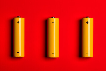 Yellow AA alkaline batteries on red background