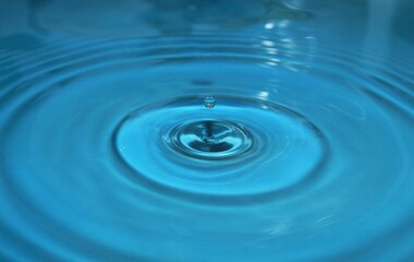Naklejka na ściany i meble water drop splash background blue, water ripple and antibubble drop - water surface tension 