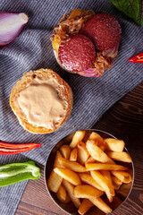 Hamburger with sausage, meatballs and caramelized onions.