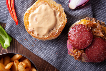 Hamburger with sausage, meatballs and caramelized onions.