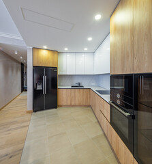 Modern interior of light wooden kitchen in apartment. White cabinets.