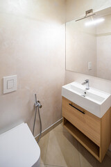 Modern interior of bathroom. White sink with wooden drawer.