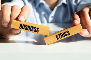 businessman holding wooden blocks with the inscription business ethics