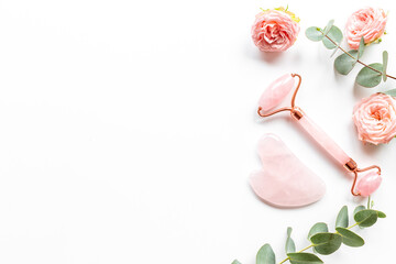 Pink gua sha massage stone and face roller with rose flowers