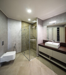 Modern interior of luxury bathroom. Wooden counter. Marble walls.
