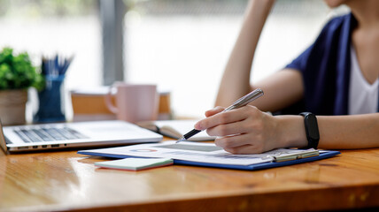 Close up of hand,Financial Businesswomen analyze the graph of the company's performance to create profits and growth, Market research reports and income statistics, Financial and Accounting concept.