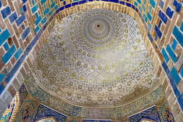 Fototapeta na wymiar Part of window opening and interior decoration of walls and vault of medieval mausoleum, known as Octahedron. Historical complex Shah-i Zinda in Samarkand, Uzbekistan