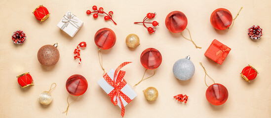 Beautiful Christmas composition. Christmas banner with red Christmas balls, gift boxes and decorations on a beige grunge background. Top view, flat lay.