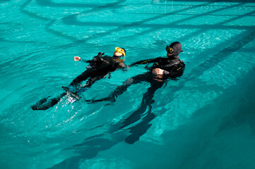 Woman and male divemaster, lesson in diving school