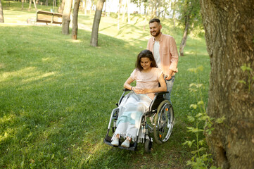 Love couple with wheelchair walking in autumn park