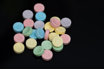 a bunch of 6 colored pills on black