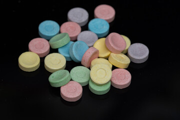 a bunch of 6 colored pills on black