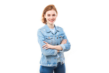 Portrait of a young red-haired girl on a white isolated background in jeans. Looks into the camera