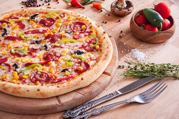 Pepperoni and sausage pizza on wooden table.