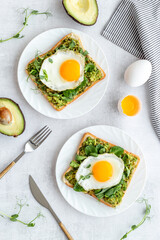 Toasts with eggs and avocado cream and spinach. Top view