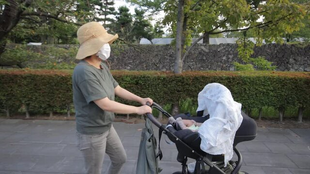 Mother walks with baby on a stroller at castle park