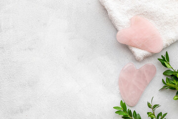 Rose quartz gua sha massage stone with green leaves