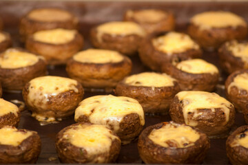 Champignons stuffed with cheese. Champignons stuffed with cheese on a baking sheet