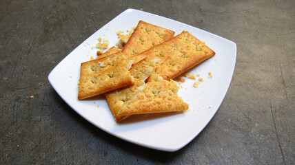 Cheese Crackers on White Plate close up from above. Suitable to place on food and beverages content.   