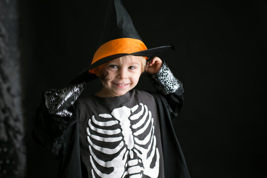 Child, dressed for Halloween, playing at home, isolated image on black