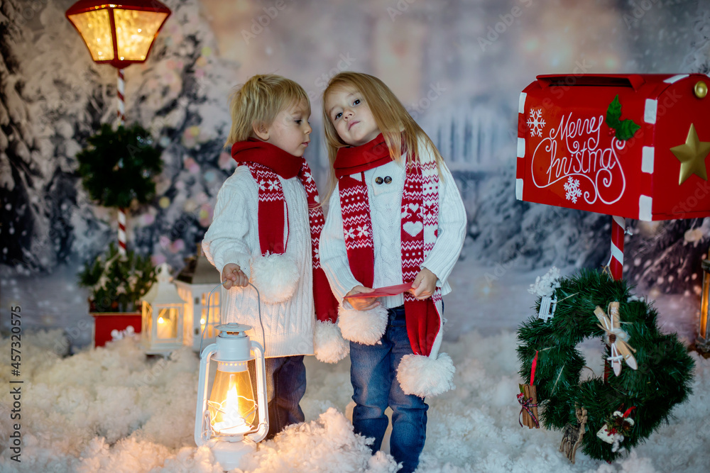 Poster Cute blond children, boy and girl, siblings, posting Christmas letter to Santa Claus, winter day