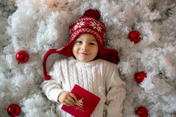 Little child, toddler boy, sending letter to santa in christmas mailbox, christmas decoration...