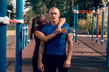 Obraz premium loving couple fit man and woman embrace at sports ground