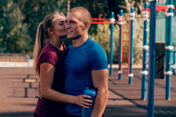 Obraz premium loving couple fit man and woman embrace at sports ground