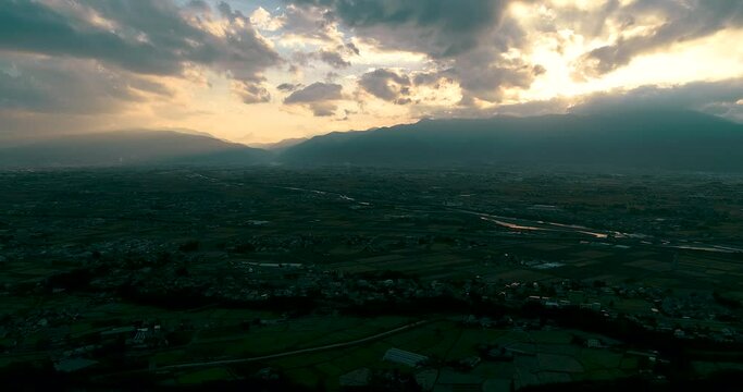 Aerial : Sun goes down on Mt and shine on rice field. Fly right