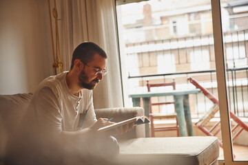 Fototapeta premium Occupied middle-aged man perusing a book