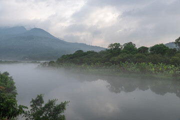 The scenery on both sides of the river in the morning fog