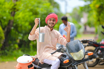 Rural scene : Indian milkman distribute milk on bike