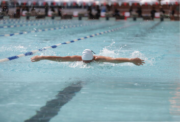 A swimmer is competing in a butterfly stroke.