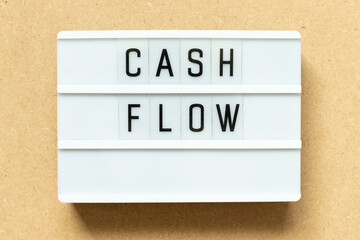 Lightbox with word cash flow on wood background