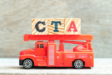 Fire ladder truck hold letter block in word CTA (Abbreviation of Call to action or Chartered tax adviser) on wood background