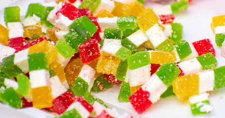 Multicolored square national sweets lie on a white background.