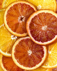 Slices of red and yellow oranges. Juicy citrus pulp. Close-up abstract background