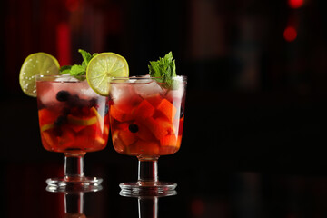 Delicious sangria cocktail on black table in bar. Space for text
