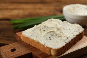 Obraz na płótnie Canvas Delicious sandwich with cream cheese on wooden table, closeup