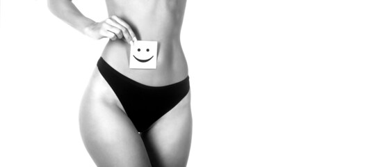 Closeup of healthy female with beautiful fit slim body in black panties holding card with happy...