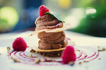 Chocolate mousse dessert with puff pastry and raspberries in restauran