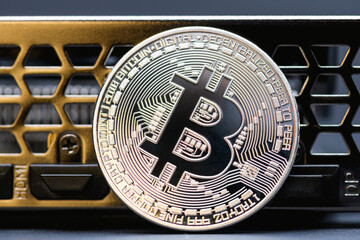 Silver Bitcoin coin on a  video Card on gray background,  close up. Crypto currency. Bitcoin mining concept